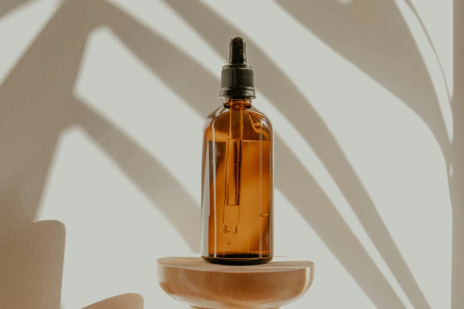 Small amber bottles and folded cloth in a wooden box by a window